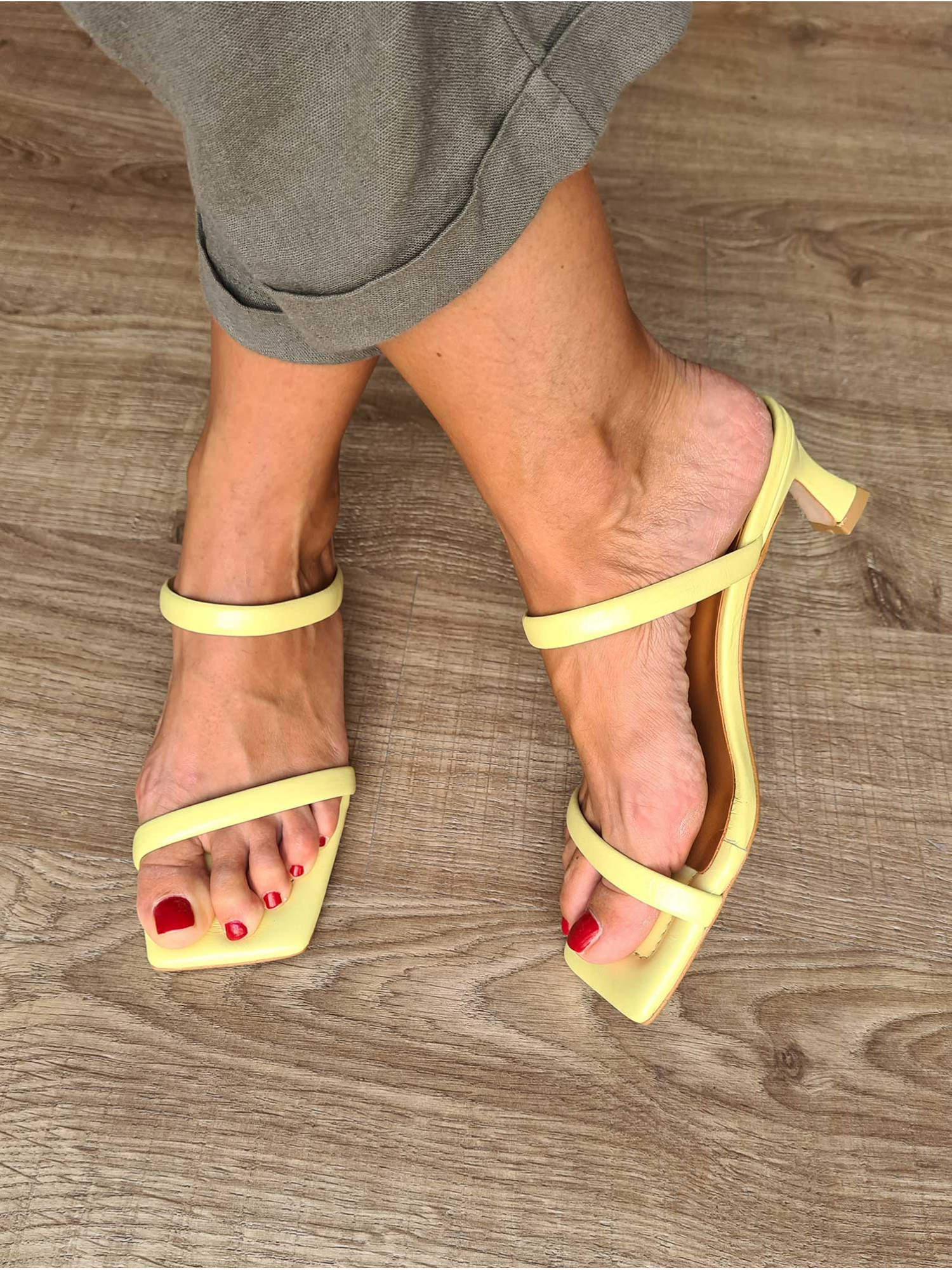 Sandalias de piel amarillas destalonadas para mujer con tiras, suela de cuero y pequeño tacón.