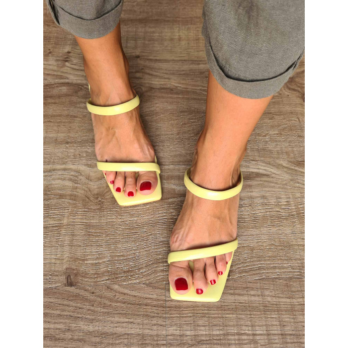 Sandalias de piel amarillas destalonadas para mujer con tiras, suela de cuero y pequeño tacón.