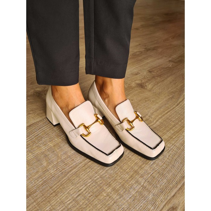 Zapato mocasín de piel de becerro color crudo con tacón medio cuadrado y detalle de cadena dorada. Hecho en España.